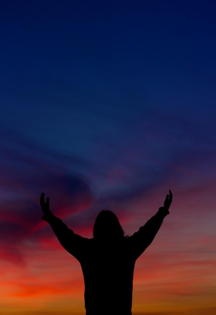 Foto la silueta de una mujer de pie contra el cielo naranja