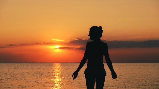 silueta, de, mujer, en la playa, en, ocaso, mujer joven, relajante, en, verano, ocaso, cielo, al aire libre, gente, libertad, estilo