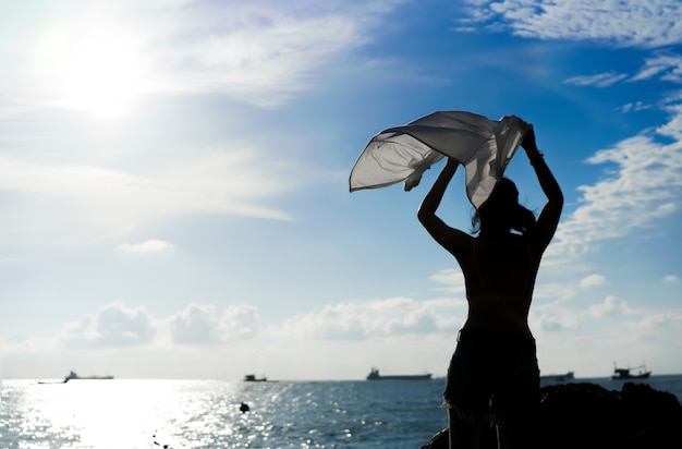 Silueta mujer relajarse en el mar en vacaciones de verano