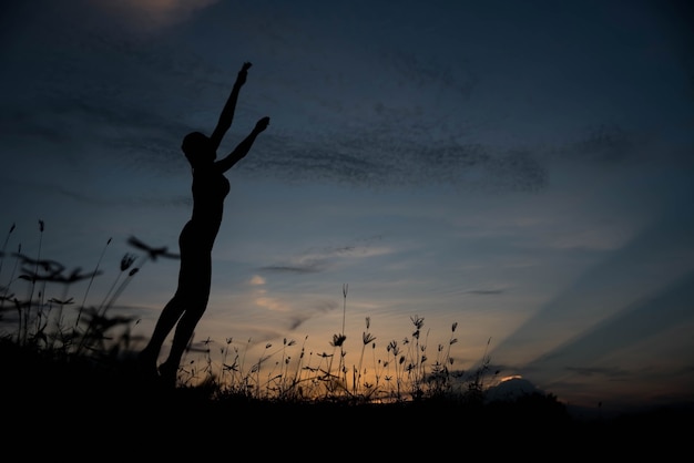 Silueta mujer saltando al atardecer