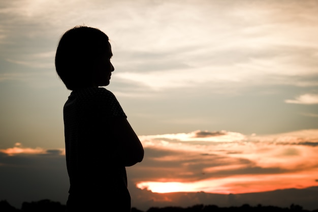 Silueta de mujer sobre fondo hermoso atardecer.