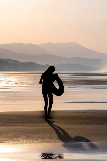 silueta, de, un, niña, ambulante, en la playa