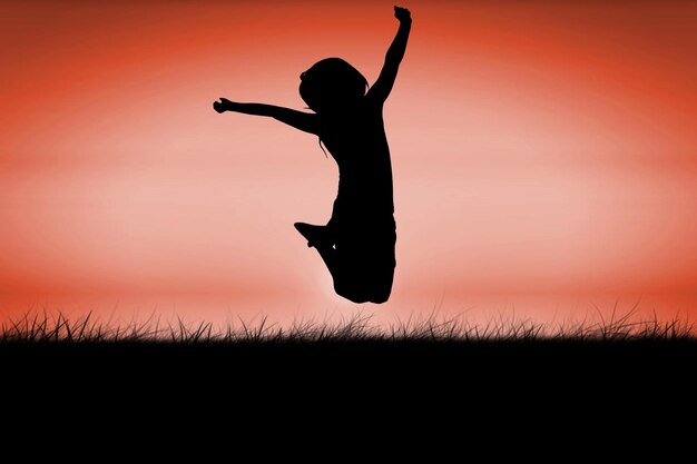 Silueta de niña saltando contra el cielo rojo sobre hierba