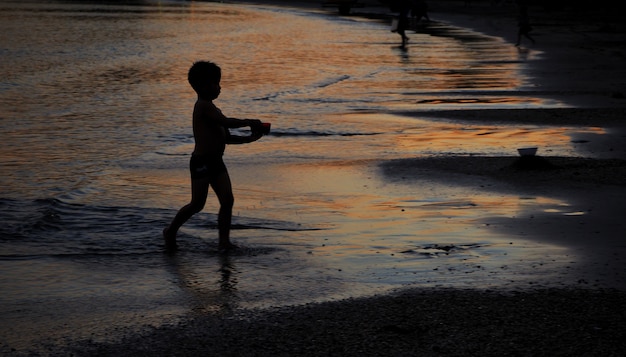 Silueta de los niños están jugando agua