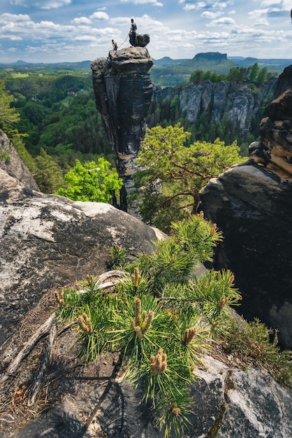 Foto silueta no reconocida de escaladores con la cuerda en la cima de la montaña en la famosa roca bastei
