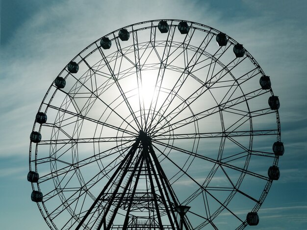 Silueta de la noria de observación en el parque de atracciones en el fondo del cielo al atardecer