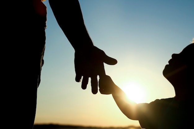 Silueta del padre tiene la mano de un niño pequeño