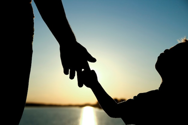 Silueta del padre tiene la mano de un niño pequeño