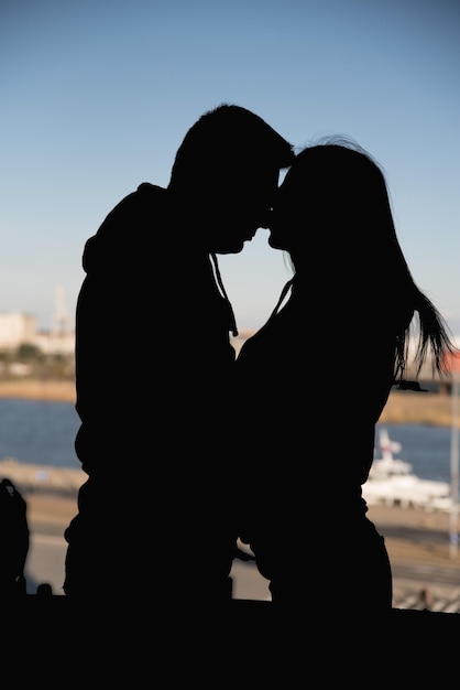 Silueta pareja besándose sobre el fondo del atardecer silueta de dos amantes amantes en el fondo de la ciudad