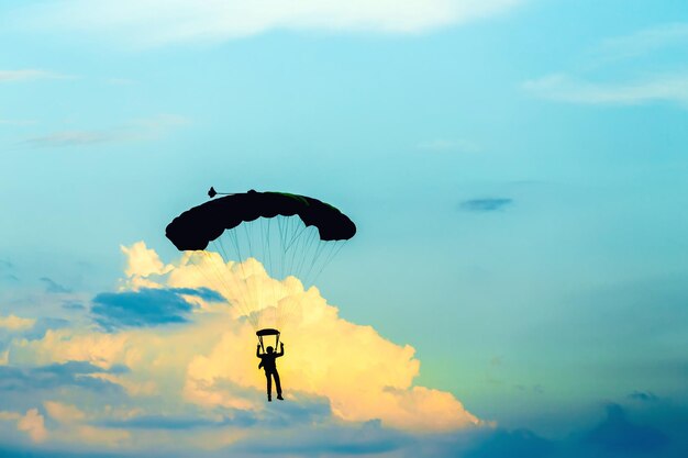 Foto silueta de una persona volando como un pájaro contra el cielo durante la puesta del sol