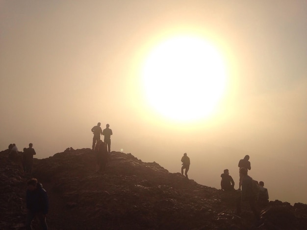 Foto silueta de personas al atardecer