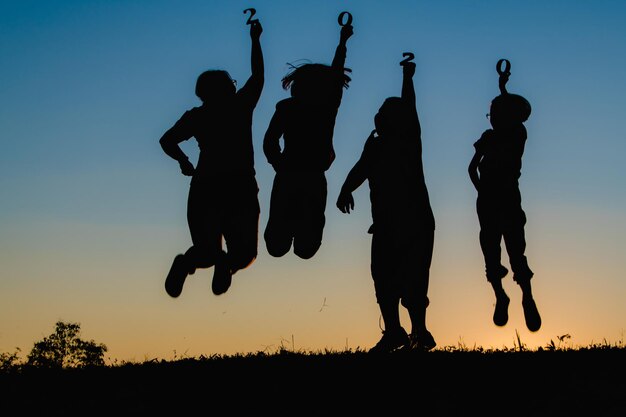 Foto silueta de personas en el campo contra el cielo durante la puesta de sol