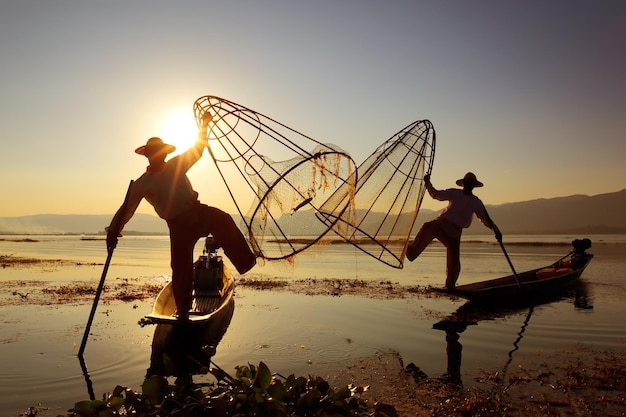 Silueta de pescadores tradicionales en el lago Inle