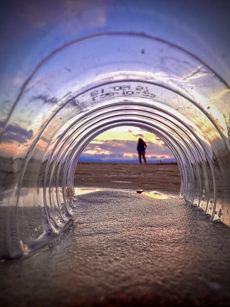 Foto silueta en la playa a través de una botella