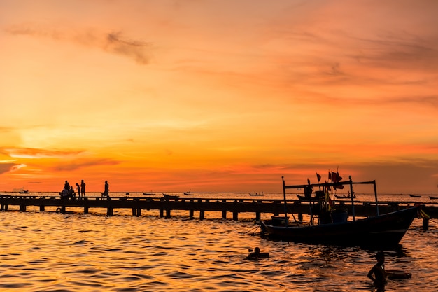 Silueta del puente del puerto y las personas durante la puesta de sol en la playa de Bang Phra, sriracha choburi, Tailandia