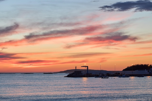 Silueta de puerto pesquero al atardecer