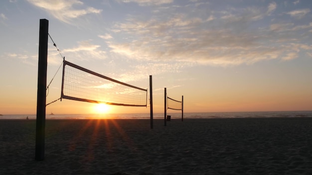 Silueta de red de voleibol en la cancha de deportes de playa al atardecer en la costa de California, EE.UU.