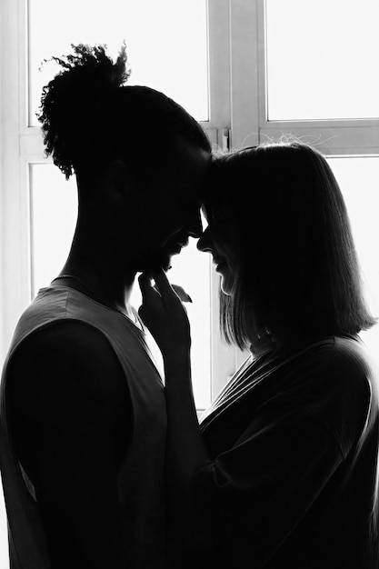 Silueta de retrato en blanco y negro de una pareja multirracial novio y novia cara a cara st