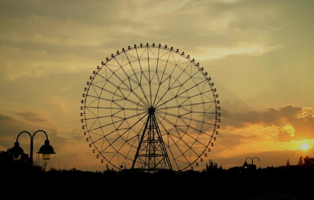 Silueta de rueda gigante de diamantes y flores en el parque kasai rinkai durante la puesta de sol