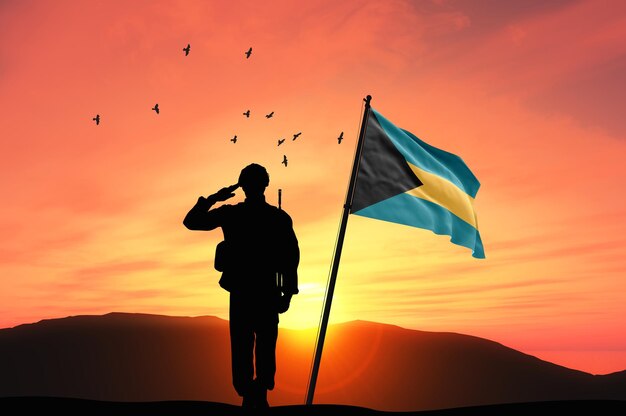 Foto silueta de un soldado con la bandera de las bahamas contra el fondo de la puesta o el amanecer