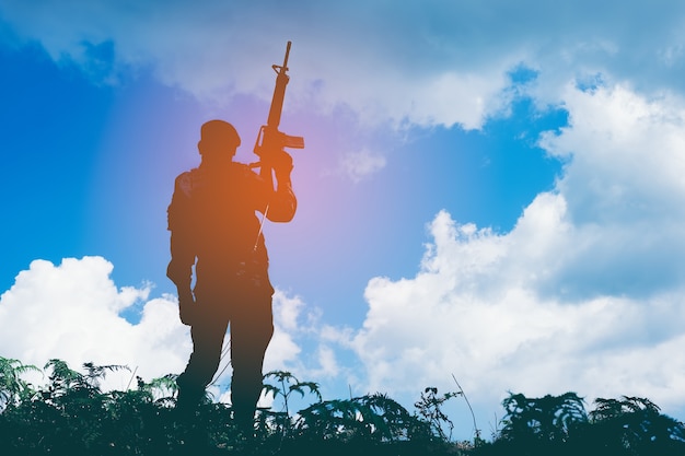 Silueta de soldado con rifle contra el sol