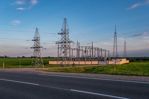 Foto silueta de las torres de pilones eléctricos de alto voltaje en el fondo de hermosas nubes nocturnas