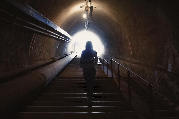 Silueta en el túnel oscuro con luz al final