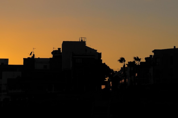 siluetas, de, casas, en, ocaso, encima, un, mar, pueblo