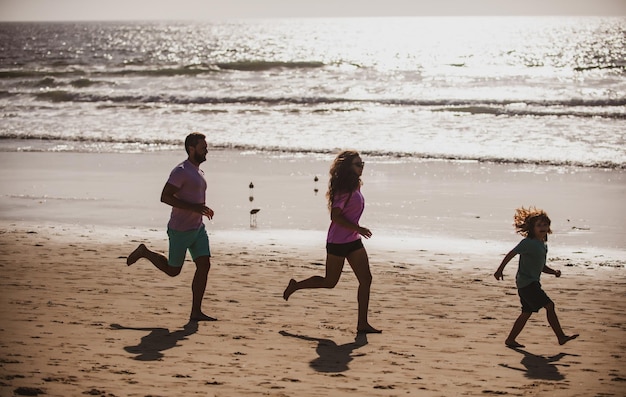 Foto siluetas de familia trotando a lo largo de la playa del mar al amanecer siluetas de entrenamiento al aire libre de corredores spor