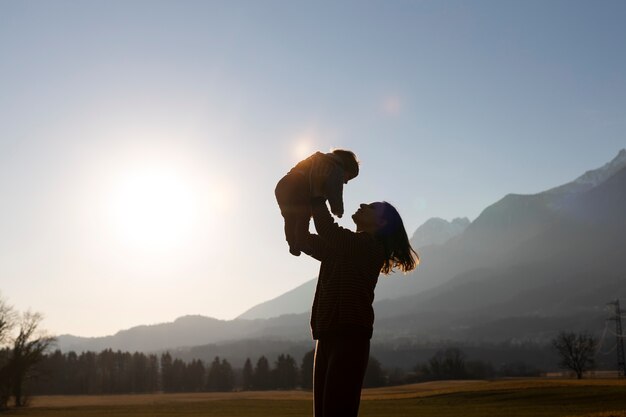 Foto siluetas de familias en la naturaleza al atardecer.