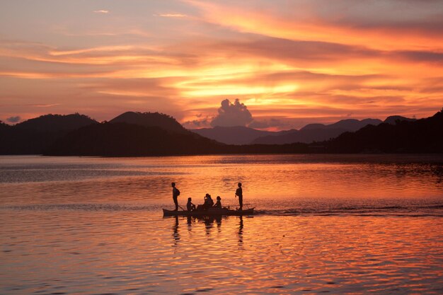 Siluetas de la gente en el barco al atardecer, Filipinas