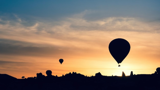 Siluetas de globos aerostáticos en las montañas al amanecer Goreme Capadocia Turquía