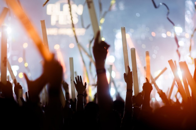 Foto siluetas de mano en concierto. luz del escenario. confeti. la multitud de siluetas de personas con las manos en alto. cinta