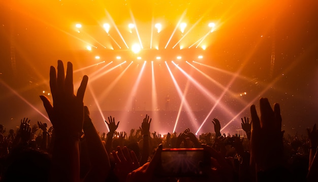 Siluetas de manos levantadas en un concierto de música. Fiesta en la discoteca