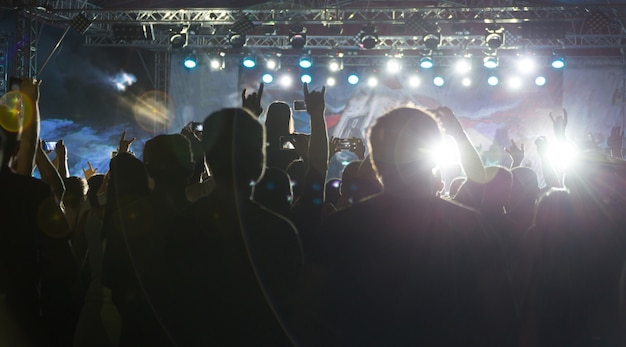 Siluetas de multitud en concierto cerca del escenario