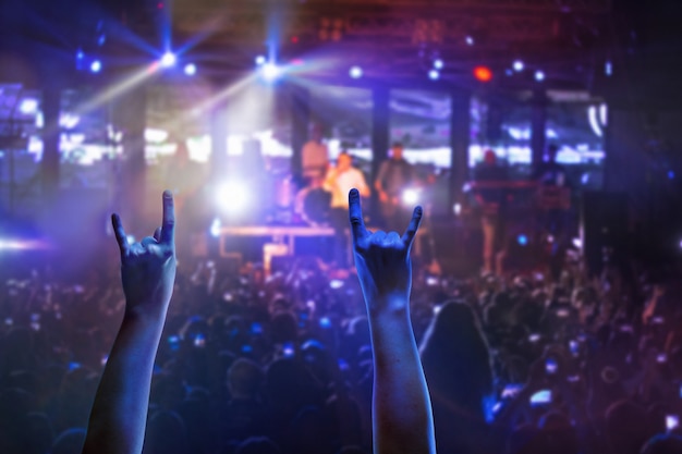 Foto las siluetas de la multitud de conciertos frente a las luces del escenario brillante. concierto de una banda de rock abstracto