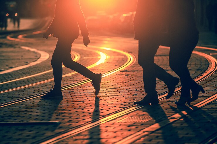 Foto siluetas de personas caminando en la calle de la ciudad y proyectando sombras en el pavimento con vías de tren en burdeos, se aplica textura de grano