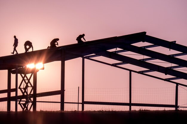 Siluetas de personas contra un cielo despejado durante la puesta de sol