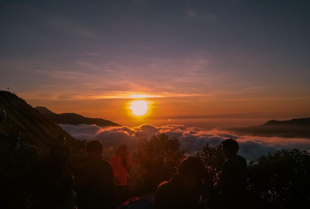 Foto siluetas de personas contra el cielo durante la puesta de sol