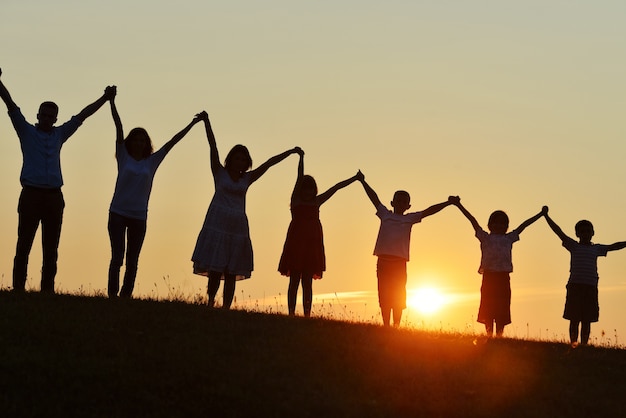 Siluetas de personas felices al aire libre en el campo