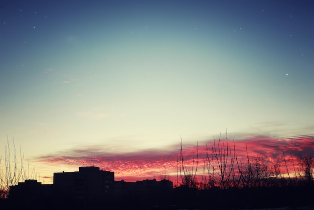 Siluetas rojas del cielo de la puesta del sol de edificios