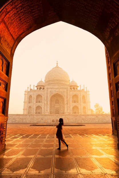 Siluetee al turista de la mujer no identificada que camina cerca de Taj Mahal en Agra la India.