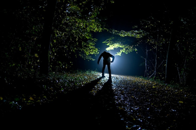 Siluette des Mannes im Wald in der Nacht