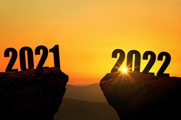 Silvester 2022 auf dem Berg bei Sonnenuntergang, Konzept. 2021 und 2022 auf der Klippe bei Sonnenaufgang, kreative Idee. Freiraum für Gestaltung