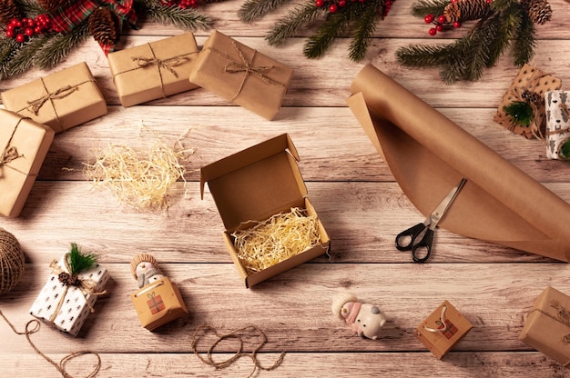 Silvester flach gelegt Weihnachtsgeschenkboxen in Bastelpapier eingewickelt Der Prozess der Vorbereitung auf das neue Jahr Einfaches Flatlay mit gepackten Kisten und einer offenen Kiste mit Sachen Offene Kiste Noel