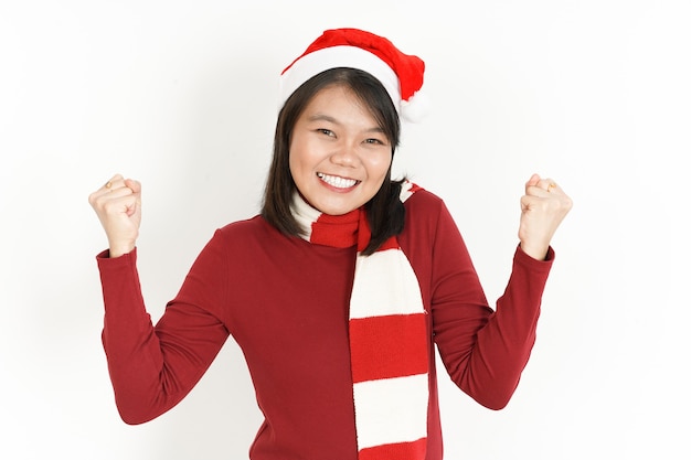 Sim, feliz gesto de bela mulher asiática vestindo gola alta vermelha e chapéu de Papai Noel isolado no branco