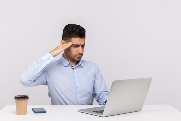 Sim senhor Funcionário sério disciplinado responsável sentado no local de trabalho do escritório saudando a tela do laptop ouvindo seu chefe dando ordem no estúdio de chamada de vídeo isolado no fundo branco