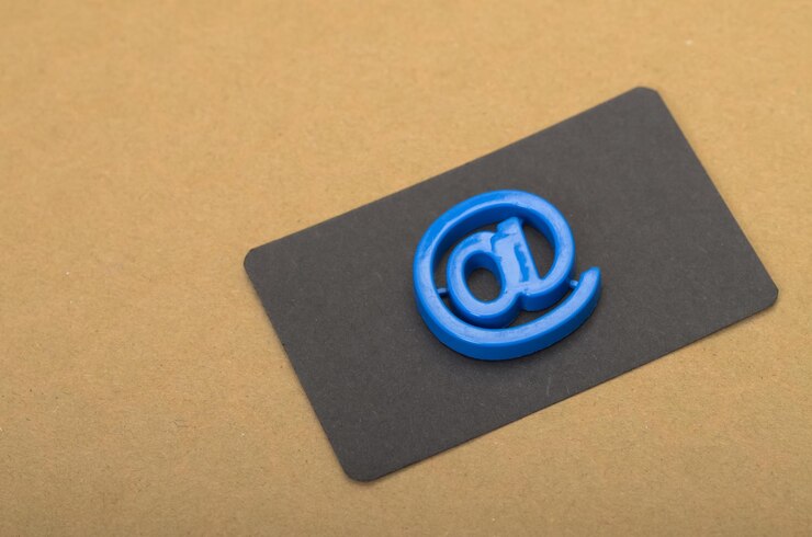 Foto un símbolo azul brillante descansa en una tarjeta negra que simboliza el concepto de correo electrónico y comunicación digital
