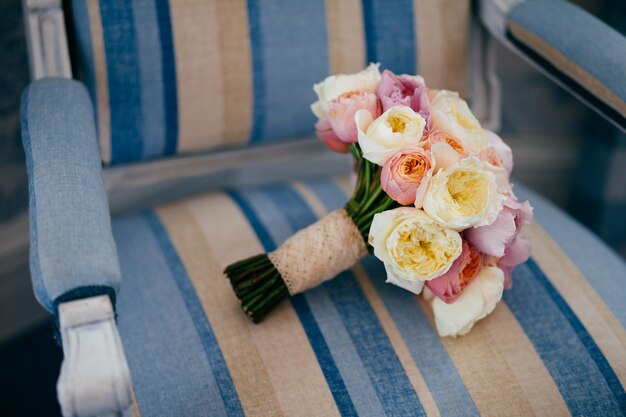 Símbolo de la boda El maravilloso ramo de boda se encuentra en un sillón vintage, preparado para una ocasión especial.