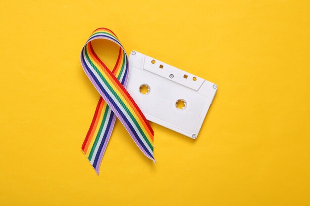 Símbolo de cinta de orgullo de cinta de arco iris LGBT con casete de audio sobre fondo blanco